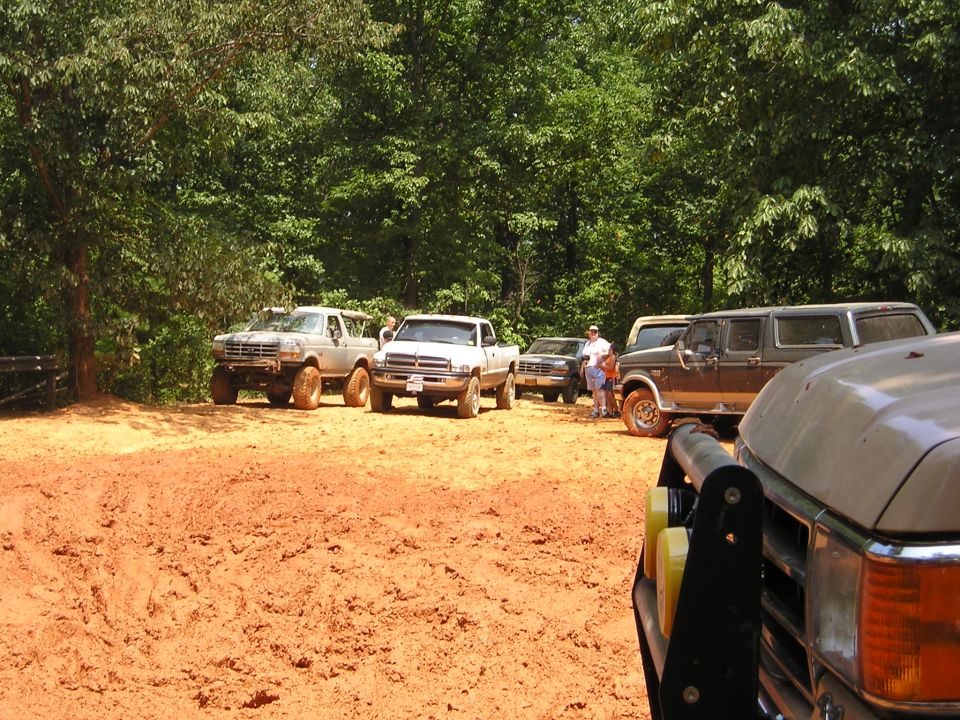 Brown 1992 Ford Bronco SUV with lifted suspension parked on dirt