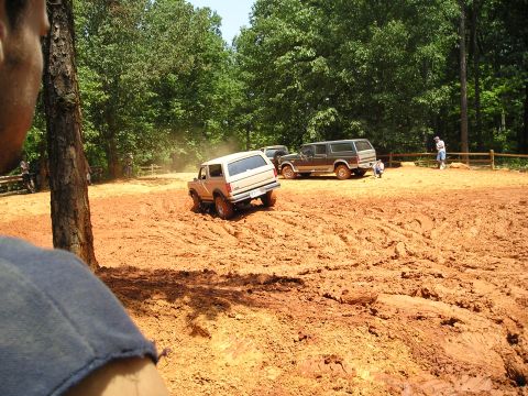 1996 Ford Bronco - Ford Bronco navigating a muddy off-road course with other vehicles present.