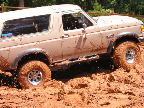 1996 Ford Bronco - This 1996 Ford Bronco is deep in the mud, showing off its off-road capabilities.