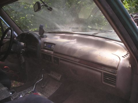 1996 Ford Bronco - The interior of a 1996 Ford Bronco shows a dusty dashboard and steering wheel.