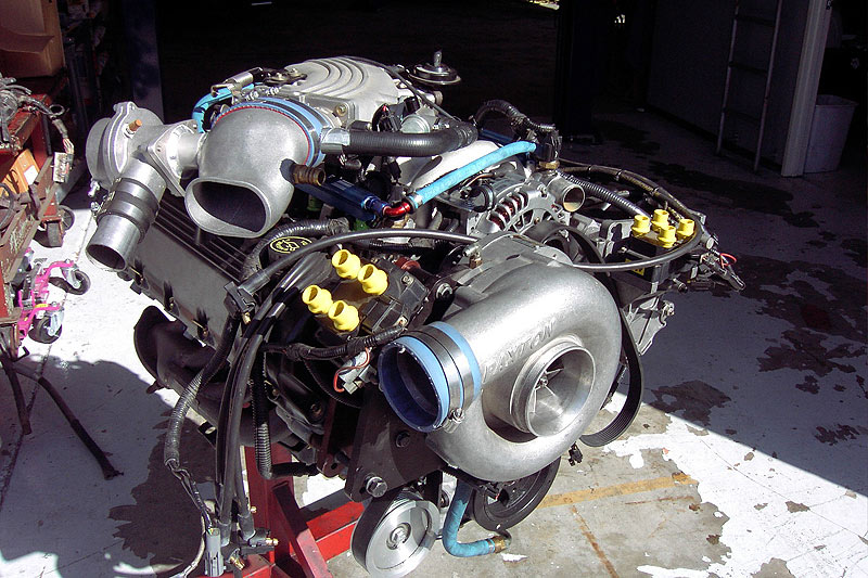 V8 engine on a stand fitted with a Paxton centrifugal supercharger, injector ports capped yellow