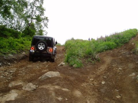 2000 Ford E350 - A Jeep Wrangler navigates a challenging off-road path.
