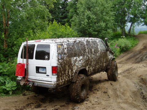 2000 Ford E350 - This van is deep in the mud on an off-road trail, showing its capabilities.