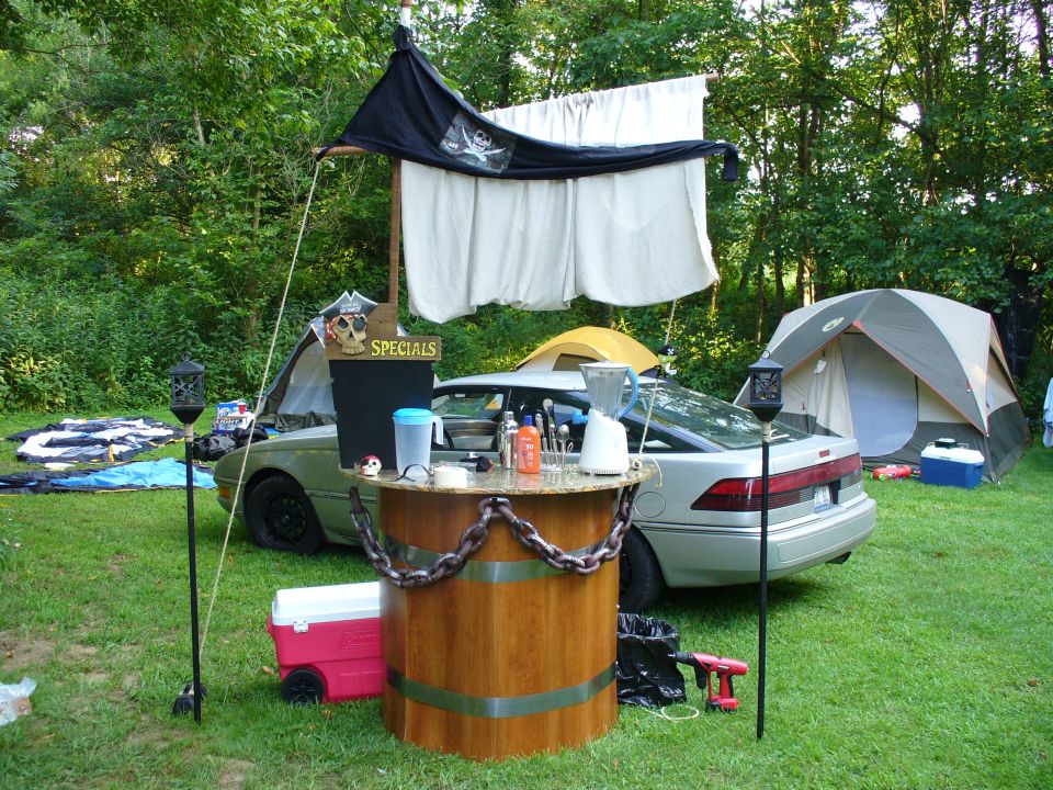 Silver hatchback with hood open, used as a bar at a campsite