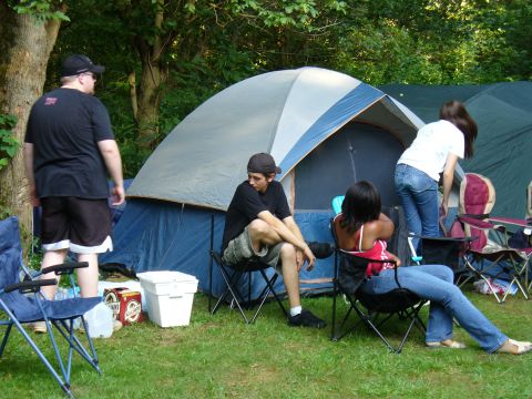 1991 Ford Probe - A group of people are enjoying a camping trip, with tents set up in a grassy area.