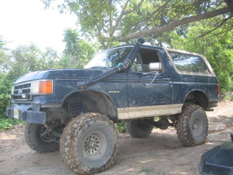 1990 Ford Bronco - This lifted 1990 Ford Bronco features a snorkel, large off-road tires, and a dark blue paint job.