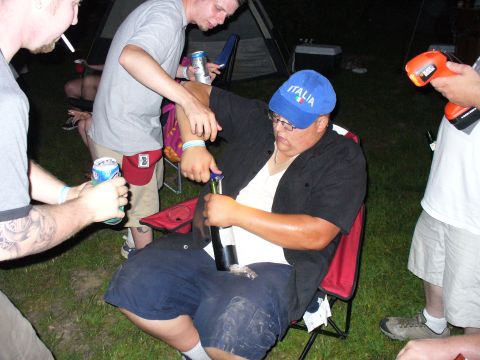 1991 Ford Probe - A group of people are gathered outdoors at night, with one person opening a bottle while others hold drinks.