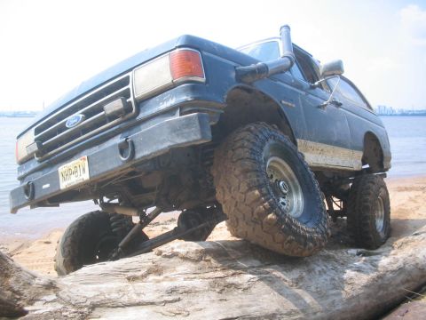 1990 Ford Bronco - Modified 1990 Ford Bronco with snorkel and off-road tires parked on a beach.
