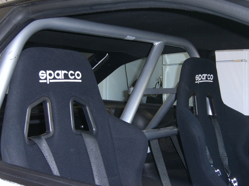 Interior shot of a car showing two Sparco racing seats and a silver roll cage