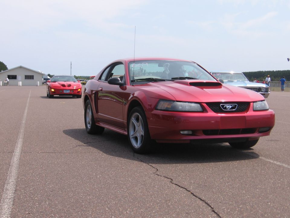 Red New Edge Mustang GT coupe with hood scoop in drag strip staging lanes