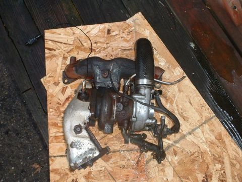 1991 Ford Probe - A turbocharger assembly, likely removed from an engine, is shown on a piece of plywood.