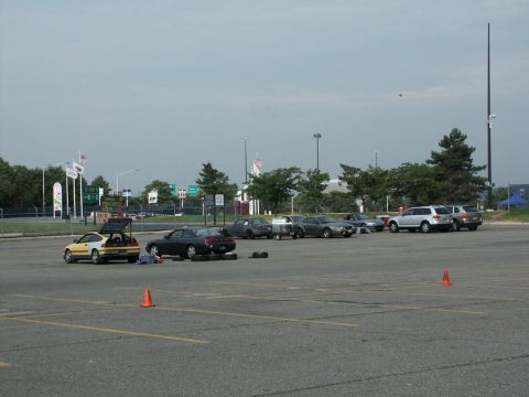 2001 Mercury Grand Marquis - Cars are parked in a lot with traffic cones, suggesting an event or practice session is underway.