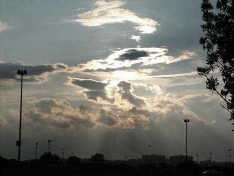2001 Mercury Grand Marquis - Sunlight breaks through dramatic clouds over a silhouetted landscape with streetlights.