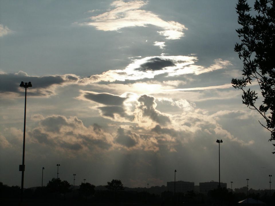 cloudy sky with sunbeams and streetlights