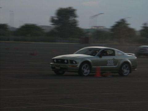2001 Mercury Grand Marquis - A light-colored coupe navigates a track with orange cones, with another vehicle visible in the background.