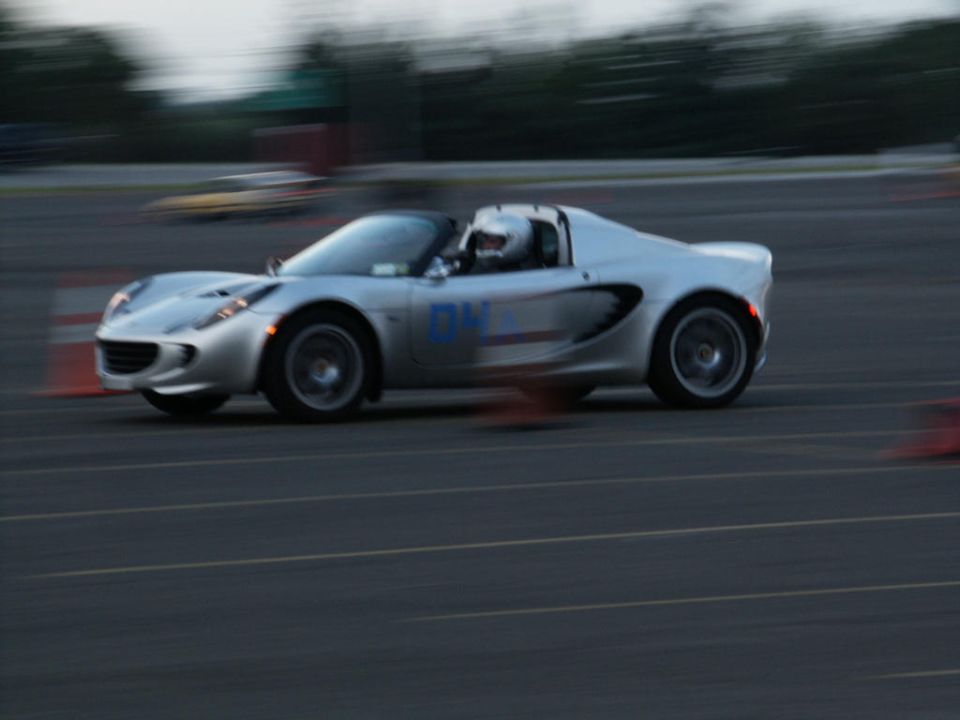 Silver Lotus Elise with blue number '04' on the door, driving on a track