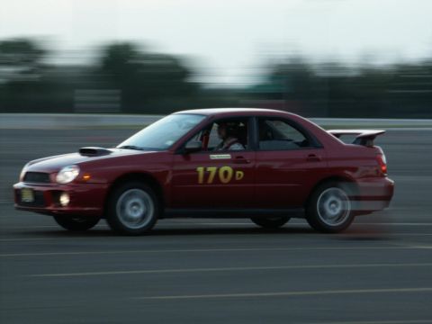 2001 Mercury Grand Marquis - Side view of a red Subaru Impreza WRX STI sedan racing on a track, displaying the number 170d.