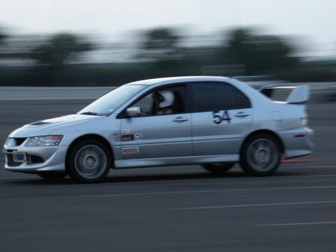 2001 Mercury Grand Marquis - Mitsubishi Lancer Evolution VIII on track, showing racing modifications and driver in helmet.
