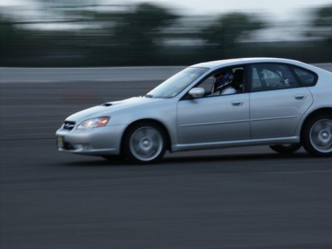 2001 Mercury Grand Marquis - A silver sedan with a driver wearing a helmet is seen on a track with motion blur. The registry claims it is a 2001 Mercury Grand Marquis,…