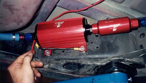 1992 Ford Crown Victoria - Red anodized Aeromotive external fuel pump and inline fuel filter mounted on a bracket against the underbody floor pan, plumbed with blue A…