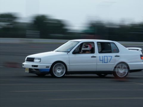 2001 Mercury Grand Marquis - A white sedan with racing number 407 is seen on a track, with motion blur indicating movement.
