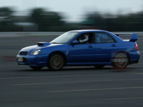 2001 Mercury Grand Marquis - A blue Subaru Impreza WRX STI with racing number 746 is captured in motion on a track.