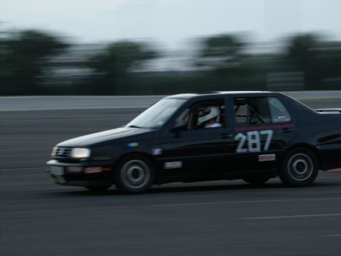 2001 Mercury Grand Marquis - A black sedan with racing number 287 is seen on a track, blurred by motion.