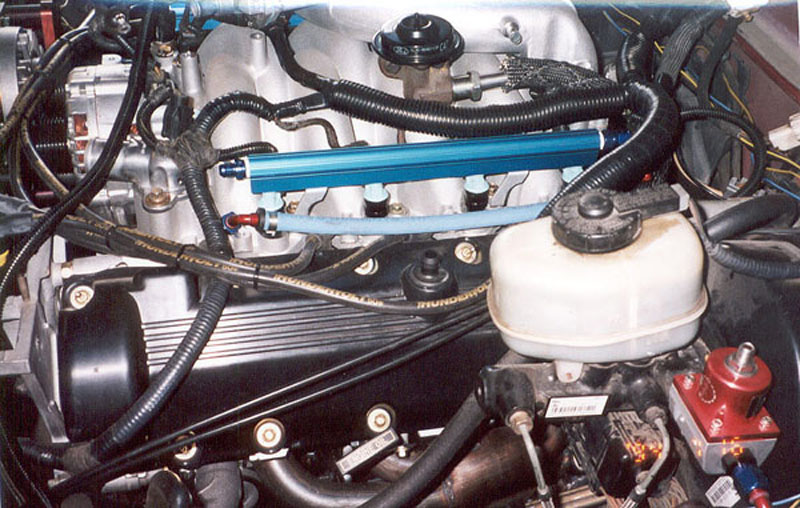 Blue anodized aluminum fuel rails and red fuel pressure regulator on a V8 engine