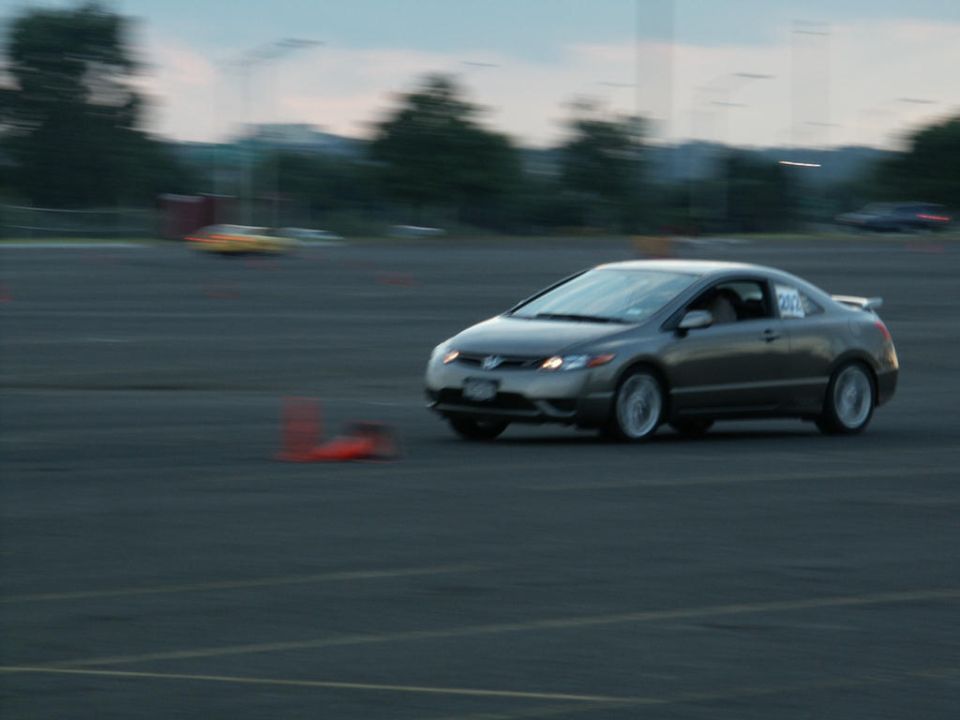 Gray coupe with white wheels on a track, number 202 on door