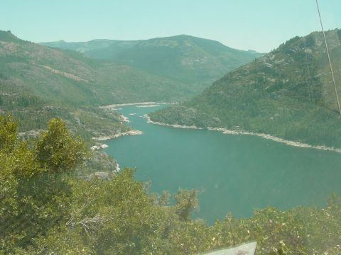 1986 Ford Bronco - A wide view of a lake surrounded by mountains and trees, with the Supermotors.net logo in the corner.