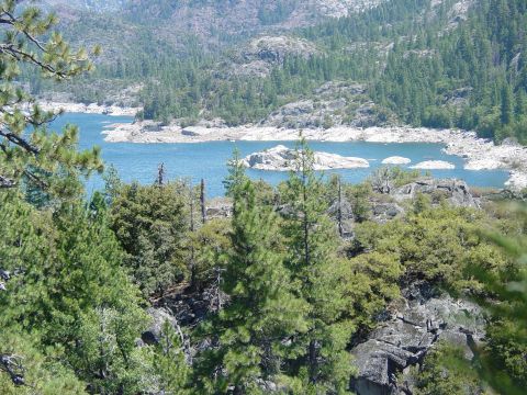 1986 Ford Bronco - Scenic view of a mountain lake surrounded by pine trees and rocky terrain.