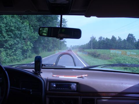 1996 Ford Bronco - Driving down a two-lane road with trees and fields on either side, another vehicle is in the distance.