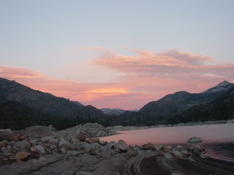 1986 Ford Bronco - A landscape unfolds with mountains framing a tranquil lake under a sky painted with the soft hues of dusk.