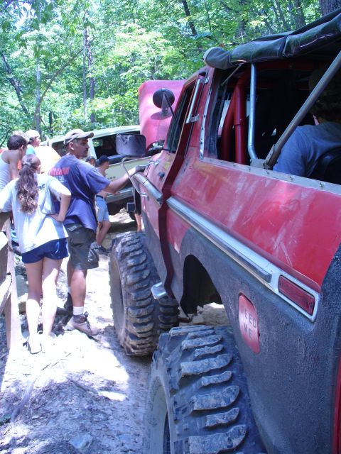 1996 Ford Bronco - This modified off-road vehicle, likely from the late 1970s, is seen with oversized tires and a roll cage, suggesting it's prepared for terr…