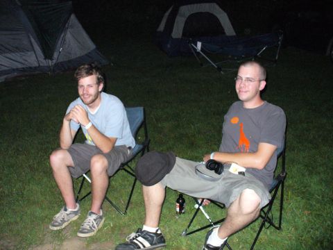1991 Ford Probe - Two men relax in camping chairs at night, with tents visible behind them.