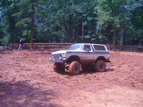 1996 Ford Bronco - A silver 1996 Ford Bronco is parked on a dirt road surrounded by trees.