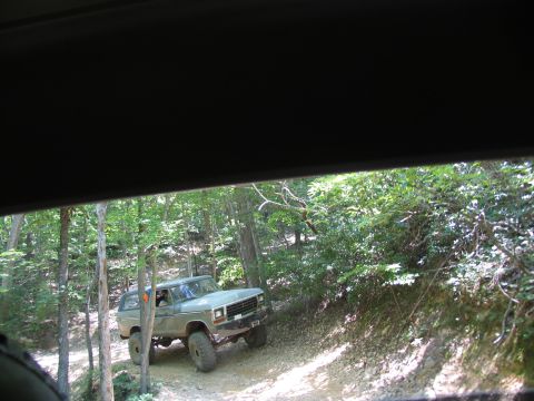 1995 Ford C-350 (Centurion Conversions) - Ford Bronco navigating a dirt path through a forest during an off-road event.