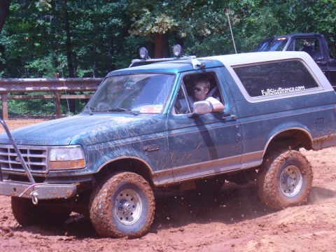 1996 Ford Bronco - This 1996 Ford Bronco is navigating a challenging muddy terrain during an off-road excursion.
