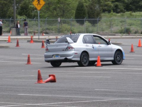 2001 Mercury Grand Marquis - A silver sedan with a prominent rear spoiler navigates a course marked by orange traffic cones.