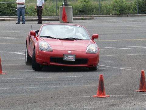 2001 Mercury Grand Marquis - A red convertible sports car navigates a course marked by orange cones.