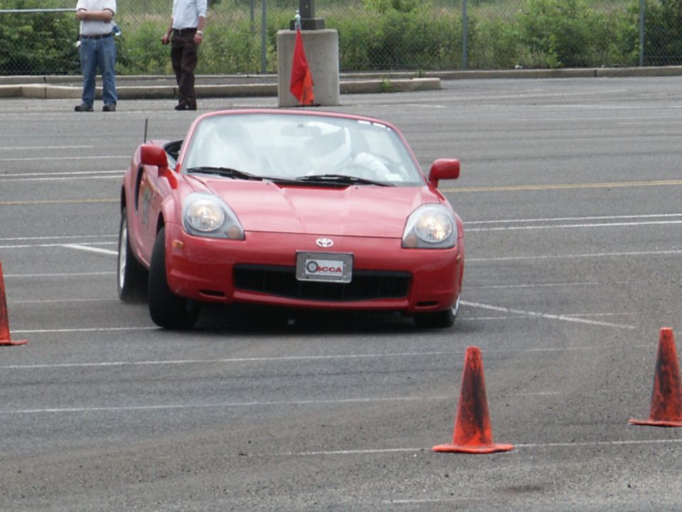 Red convertible sports car with a license plate that says 'OODA'