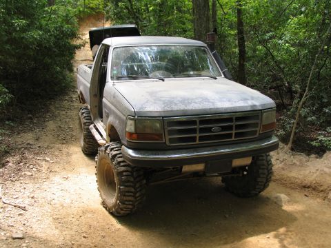 1995 Ford C-350 (Centurion Conversions) - A lifted 1995 Ford C-350 (Centurion Conversions) pickup truck navigates a wooded trail in Uwharrie National Forest.