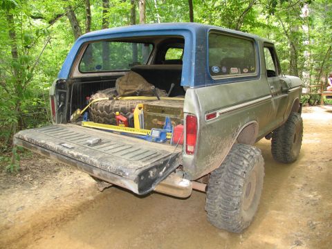 1995 Ford C-350 (Centurion Conversions) - Off-road Bronco loaded with equipment, ready for adventure in a wooded area.
