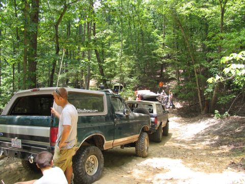 1995 Ford C-350 (Centurion Conversions) - Several Ford Broncos are lined up on a wooded trail during an off-road event in July 2006.