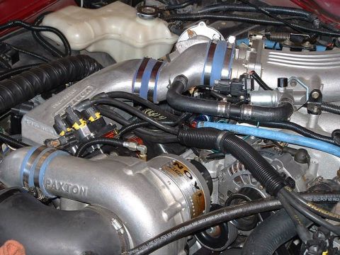 1992 Ford Crown Victoria - Detailed engine bay view of a Paxton centrifugal supercharger mounted low on the front of a V8, its cast housing marked "PAXTON" and feedin…