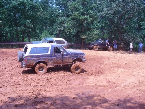 1996 Ford Bronco - Several vehicles are stuck in the mud during an off-road event.