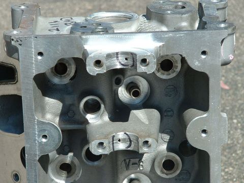 1992 Ford Crown Victoria - Close-up of a bare aluminum overhead-cam cylinder head sitting in daylight, viewed down onto the cam journal saddles, bolt holes and valve-…
