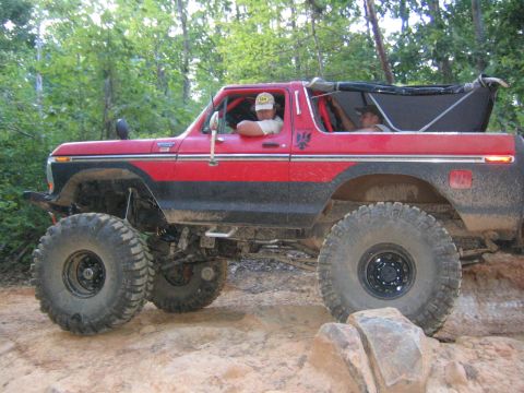 1979 Ford Bronco - Modified 1978 Ford Bronco navigating an off-road trail with large tires.