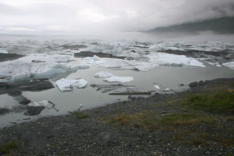 2003 Jeep TJ - A vast expanse of icebergs drifts in a calm glacial lake, with fog obscuring the distant mountains.