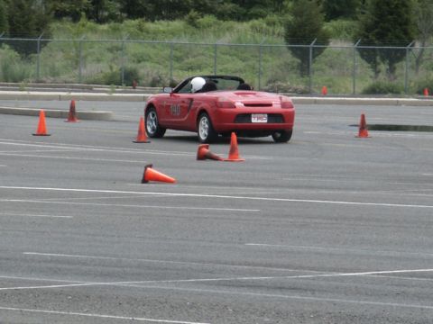 2001 Mercury Grand Marquis - A red convertible sports car, marked with the number 190, drives through a cone course during an event.